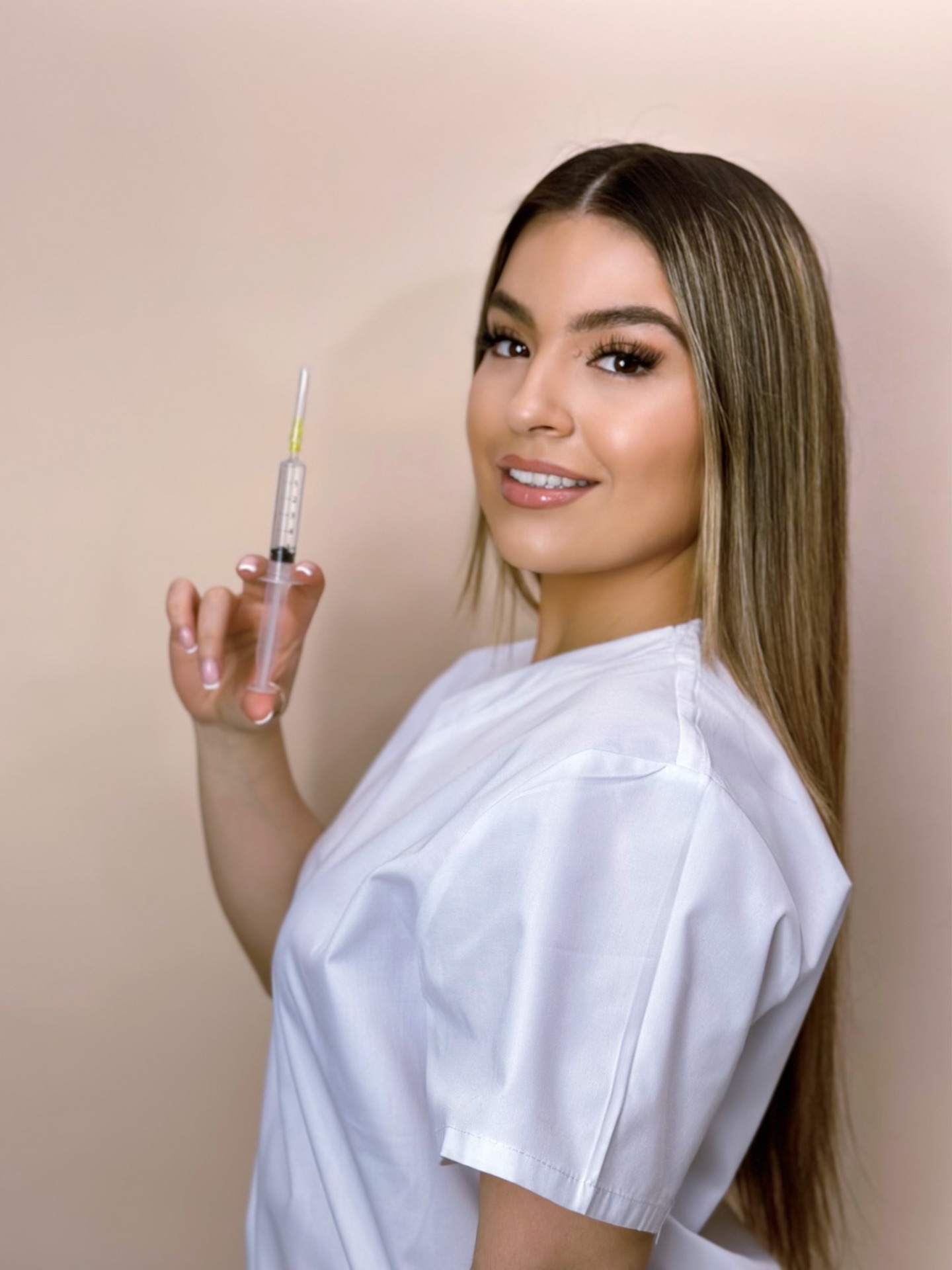 LadyJo London clinician holding an injectable in a bright modern clinic